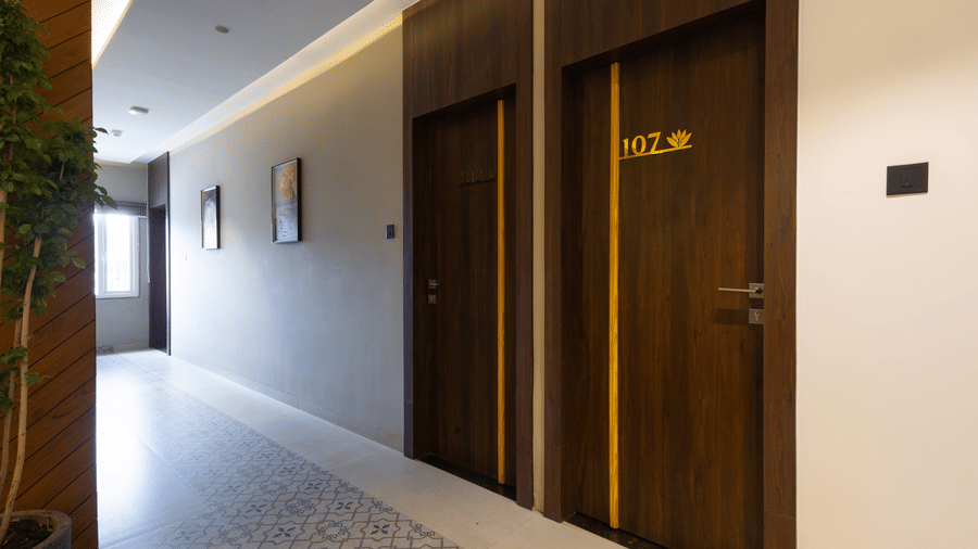 Interior view of a hallway showing multiple closed wooden doors at Pravasa Stay Luv Kush, Indore.