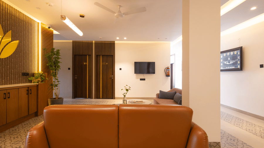 Interior view of the reception and lobby area with a brown sofa at Pravasa Stay Luv Kush, Indore.
