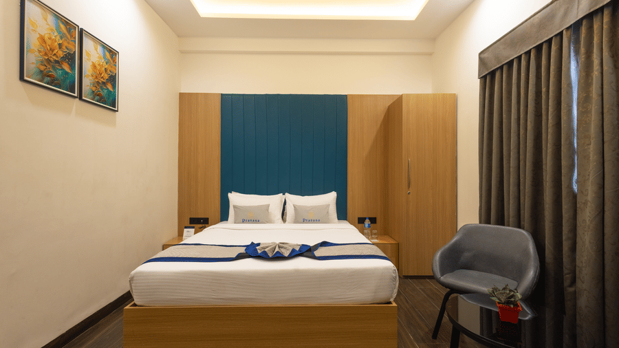 Interior view of a guest room with a bed and blue headboard at Pravasa Stay Luv Kush, Indore.
