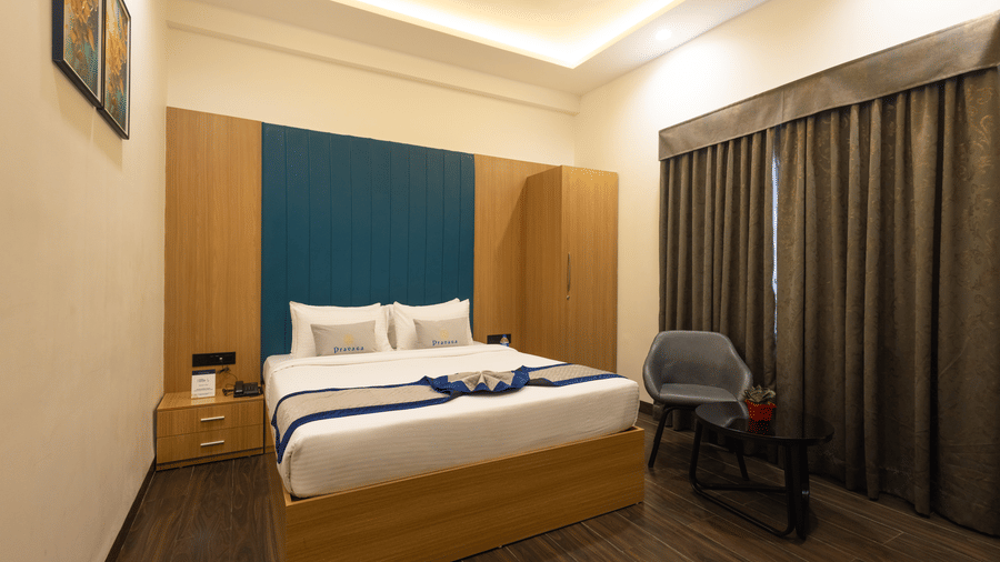 Interior view of a guest room showing the bed and window with closed curtains at Pravasa Stay Luv Kush, Indore.