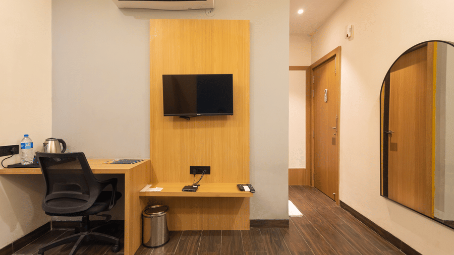Interior view of a guest room showing the television, desk, and doorway at Pravasa Stay Luv Kush, Indore.