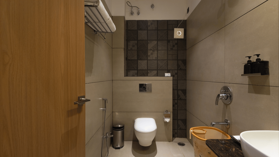 Interior of a bathroom with a toilet, shower area, and bath at Pravasa Stay Luv Kush, Indore.