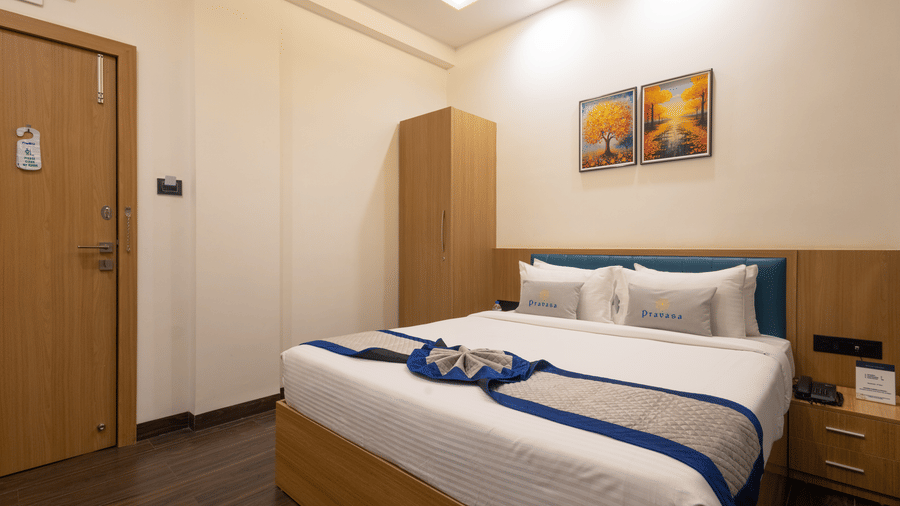 Interior of a guest room showing the bed and wooden cupboard at Pravasa Stay Luv Kush, Indore.