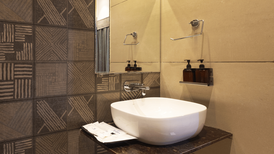 Interior of a bathroom showing the sink and decorative wall tiles at Pravasa Stay Luv Kush, Indore.