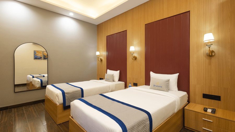 Interior view of a guest room showing 2 single beds and a mirror at Pravasa Stay Luv Kush, Indore.