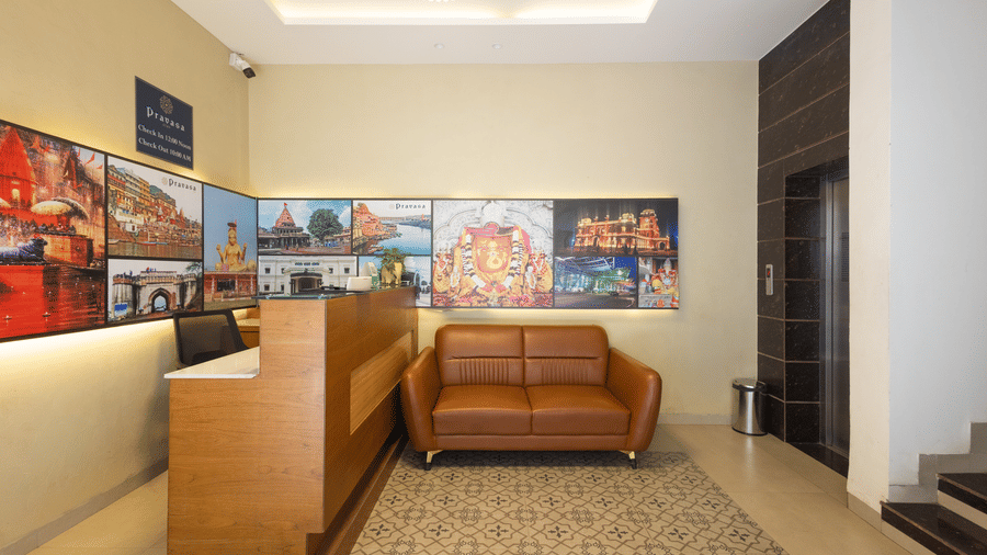 Interior view of the reception area showing the seating arrangement and decorative wall art at Pravasa Stay Luv Kush, Indore.