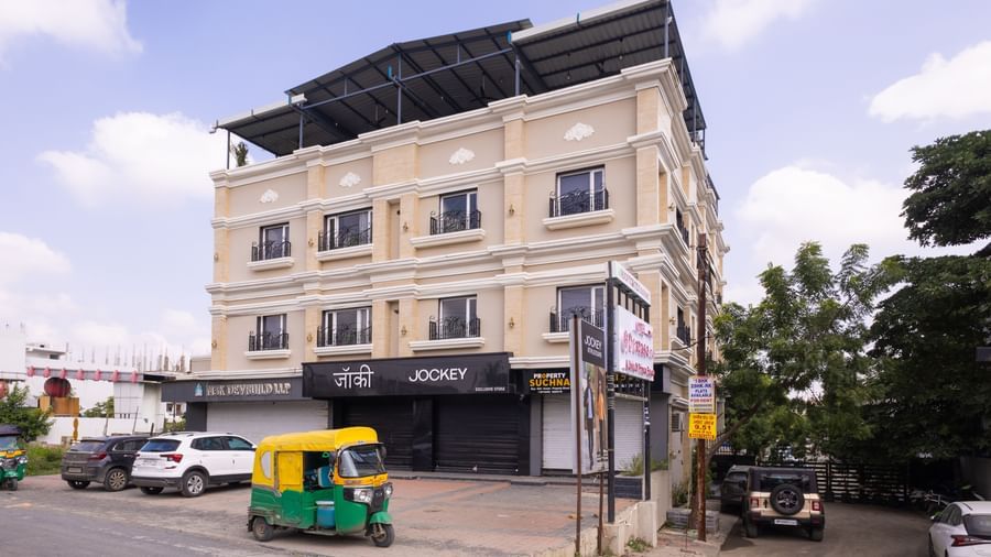 Exterior full view of the three-storey building of Pravasa Stay Luv Kush, Indore with a vehicle visible nearby.