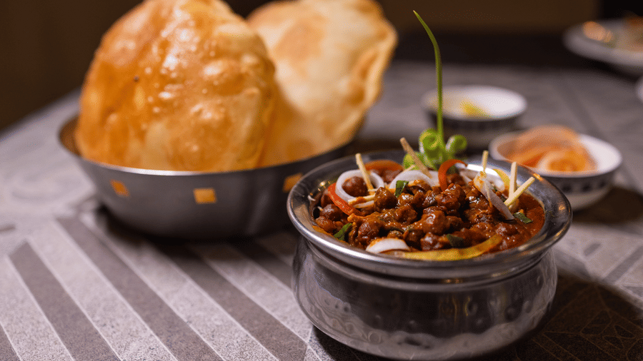View of Indian fried bread, likely puri with a curry side dish at Pravasa Stay Luv Kush, Indore.