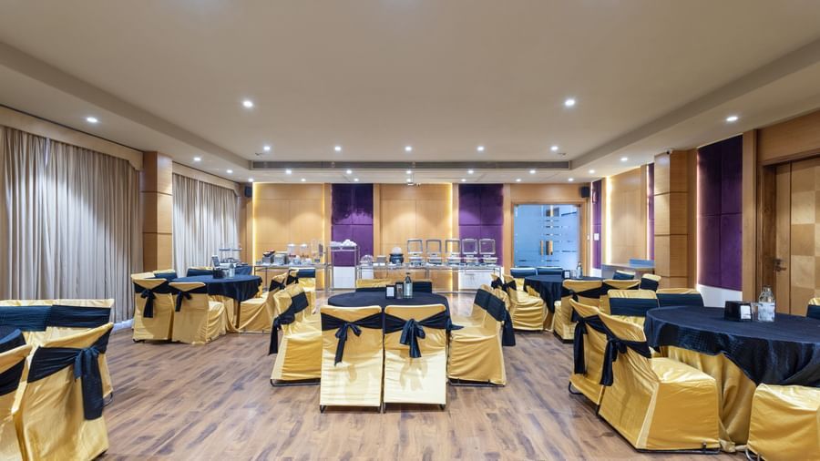 Banquet hall, Iris, with tables in cluster seating arrangment, wooden flooring, seen at Pravasa Stay Vijay Nagar, Indore.