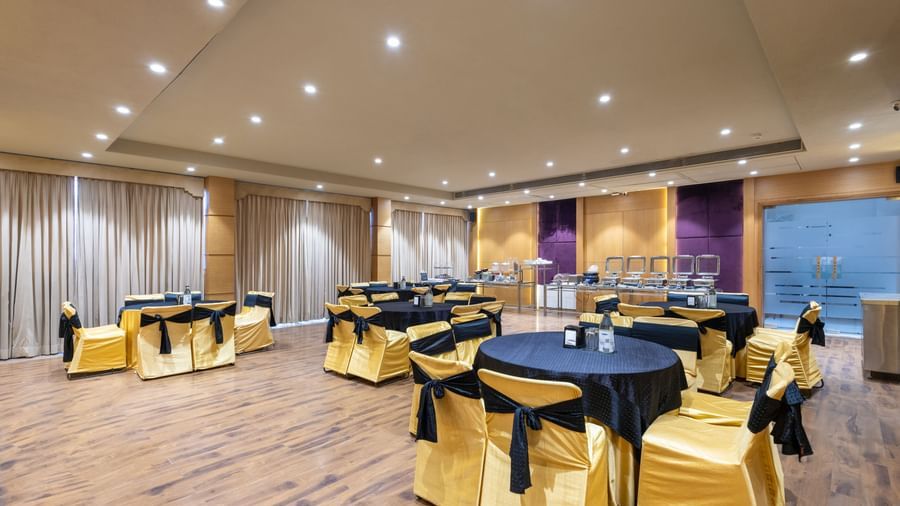 Banquet hall, Iris, with tables in cluster seating arrangment, wooden flooring, seen at Pravasa Stay Vijay Nagar, Indore.