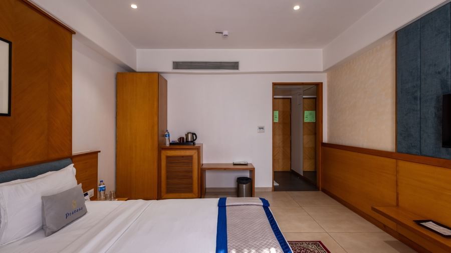 Side view of the bed, wardrobe, desk, and entryway to Executive Premium Room at Pravasa Stay Vijay Nagar, Indore.