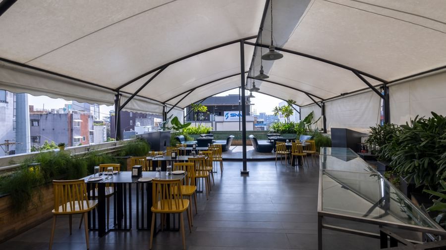 Rooftop dining setup in the Pravasa Cafe at Pravasa Stay Vijay Nagar, Indore.