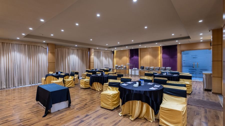 Banquet hall, Iris, with tables in cluster seating arrangment, wooden flooring, seen at Pravasa Stay Vijay Nagar, Indore.