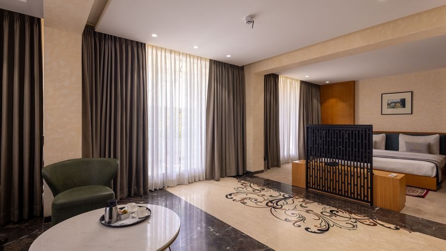 Combined view or the bedroom parted from the living area by a TV in the Suite of Pravasa Stay Vijay Nagar, Indore.