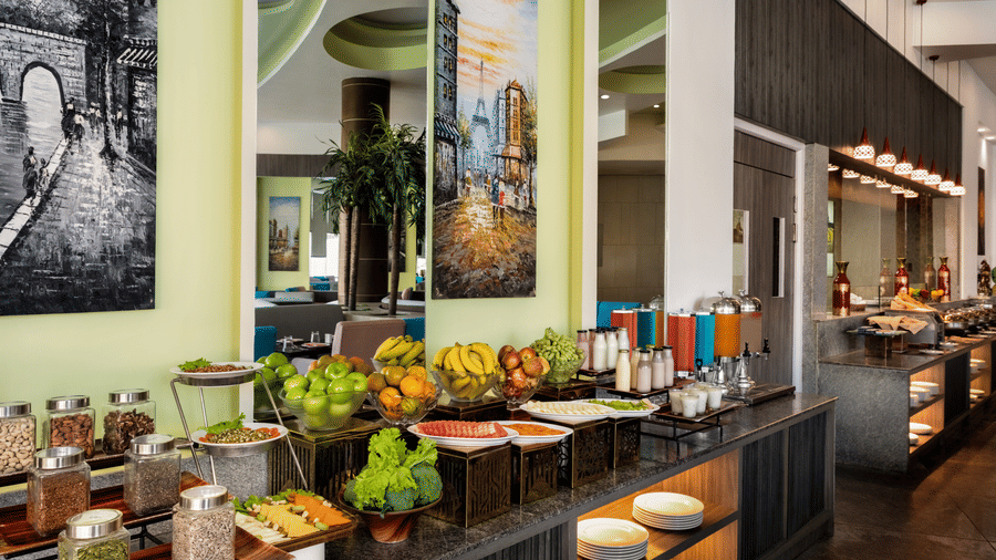Japlaan coffee shop at Ramada by Wyndham Bodh Gaya Mahabodhi featuring multiple food items neatly arranged atop a counter.