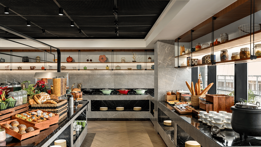 Buffet counter with a selection of dishes at Ramada Encore by Wyndham Gurugram Dwarka Expressway, offering guests a convenient dining experience.