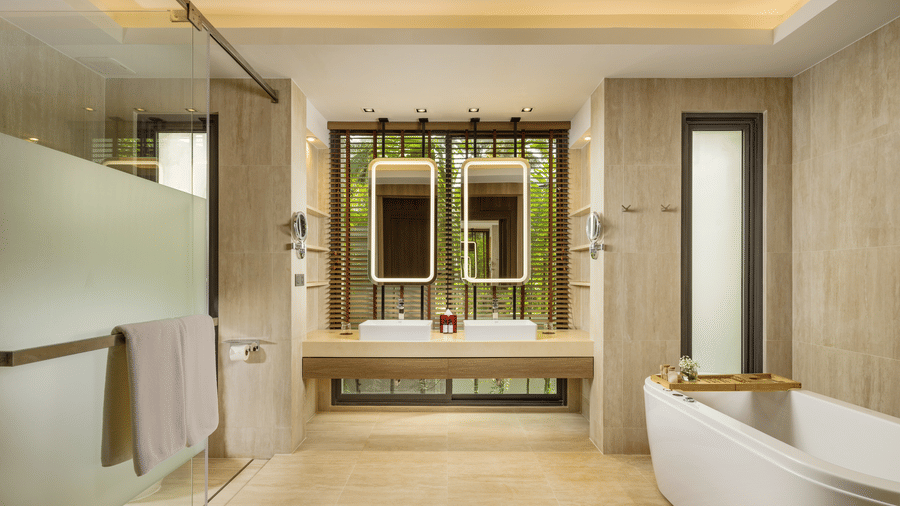 A spacious bathroom of Private Pool Villa with a bathtub, glass-enclosed shower, double vanity, and large mirrors at Ramada Resort.