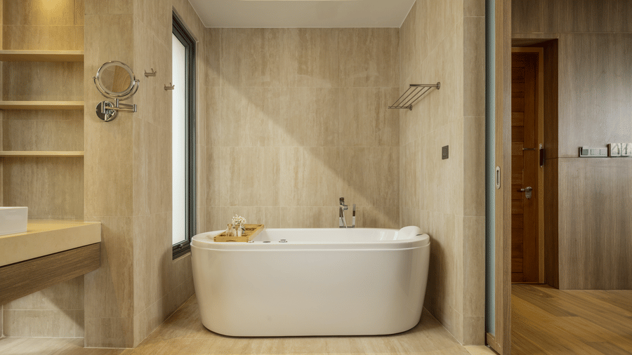 A modern bathroom of Private Pool Villa with a freestanding bathtub, open shelves, and a vanity area at Ramada Resort.