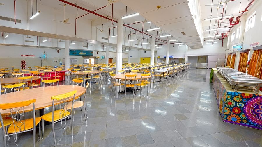 A bright cafeteria with round tables at Sahara - Family Dining in Hyderabad.