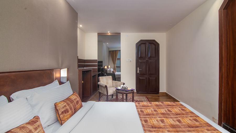An image of a room with a queen size bed, TV and a chair and a table - Sumitel Vista TV Tower