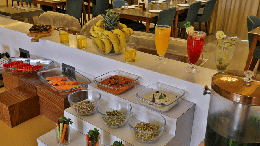 A resort buffet counter featuring fresh fruits, various juices in tall glasses, and breakfast condiments - Tathastu Chavri Resort, Jawai