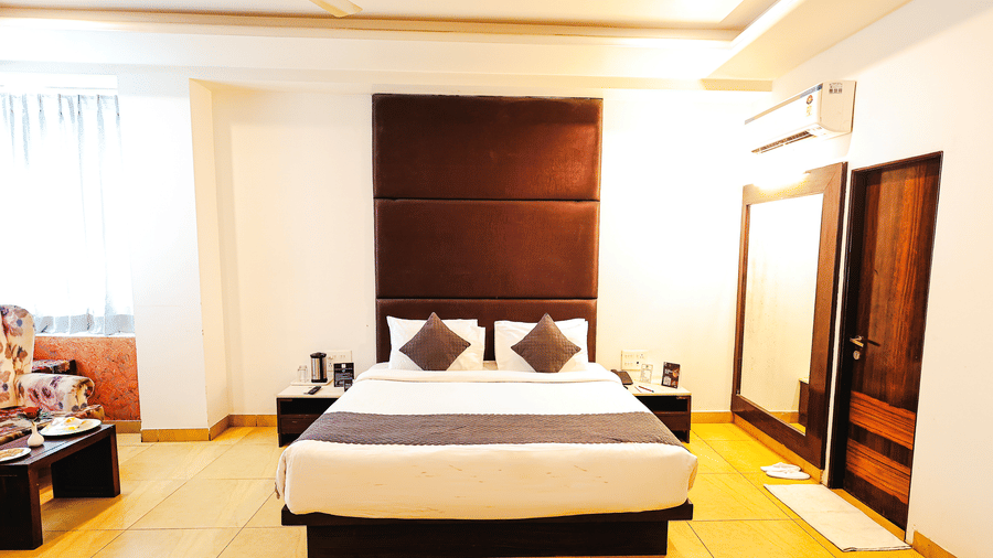 Spacious premium room with king size bed, warm lighting and contemporary interiors at TGI Apple Inn, Ajmer Road, Jaipur.