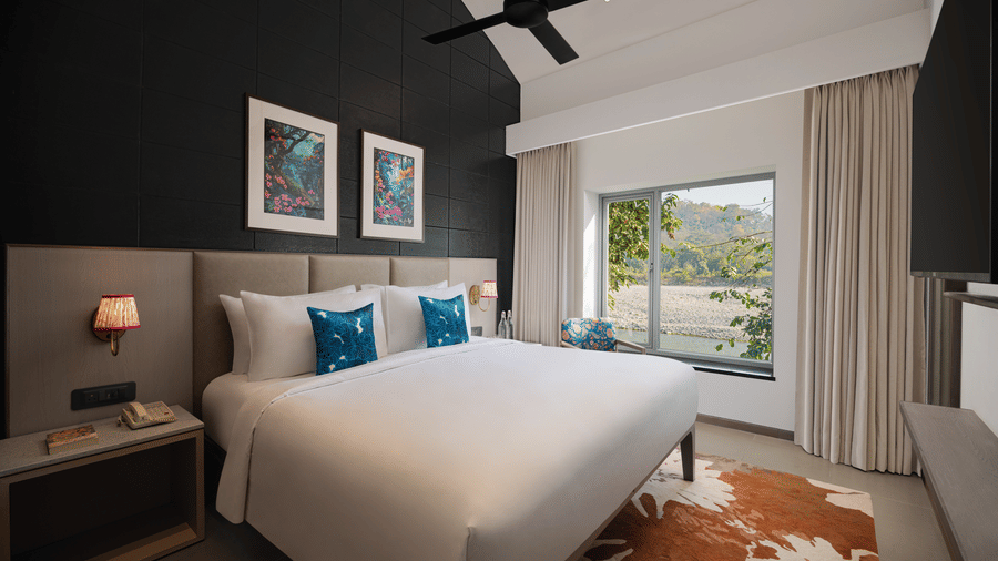 A bedroom with king bed, bedside lighting, wall art, and large window view at The Corbett Hideaway.