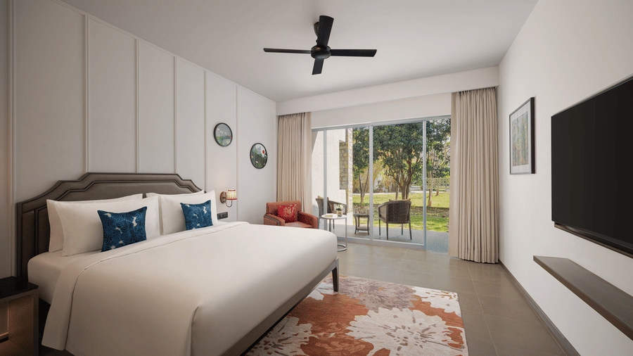 Well-lit bedroom with king-size bed, ceiling fan, wall-mounted TV, and balcony view at The Corbett Hideaway.