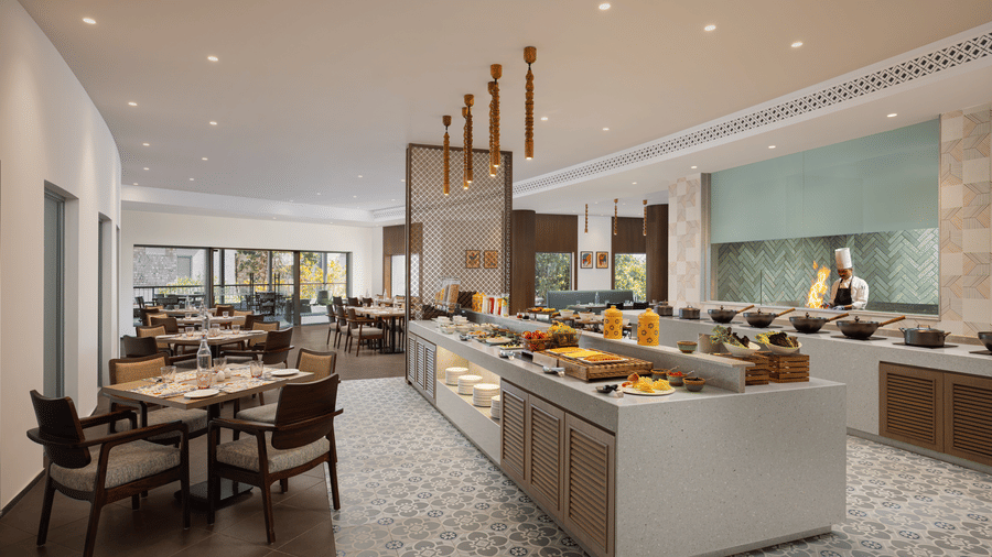 Bright buffet dining space with food counters, modern lighting, and ample seating at The Corbett Hideaway.