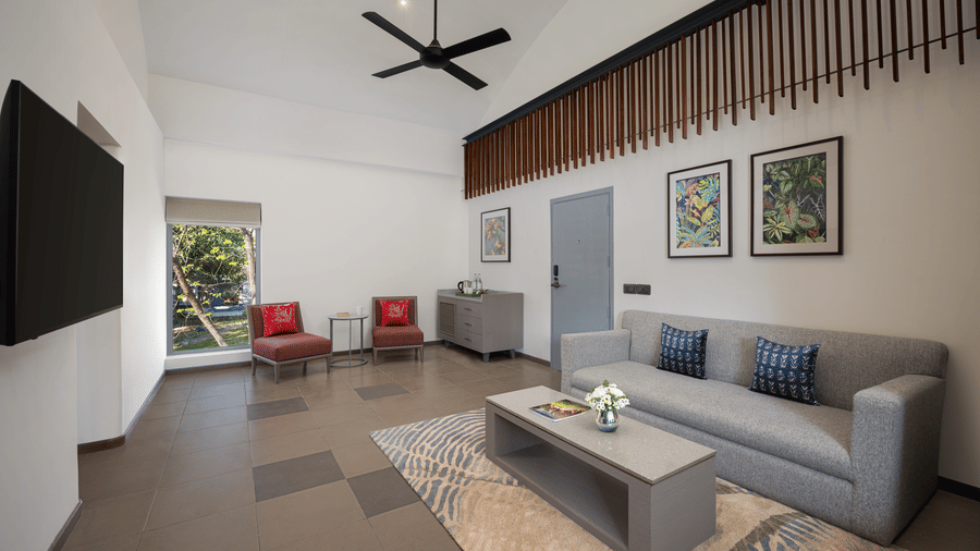Spacious suite living room with sofa seating, coffee table, and modern interiors at The Corbett Hideaway.