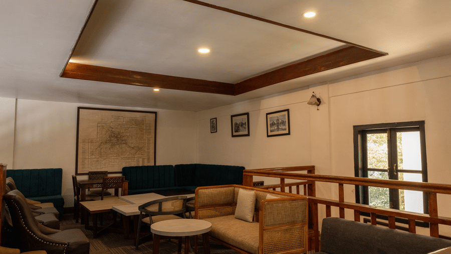 A meeting venue at The Heritage Club, Tripura, Castle, Shillong, with chairs, cushions, tables, and a window.
