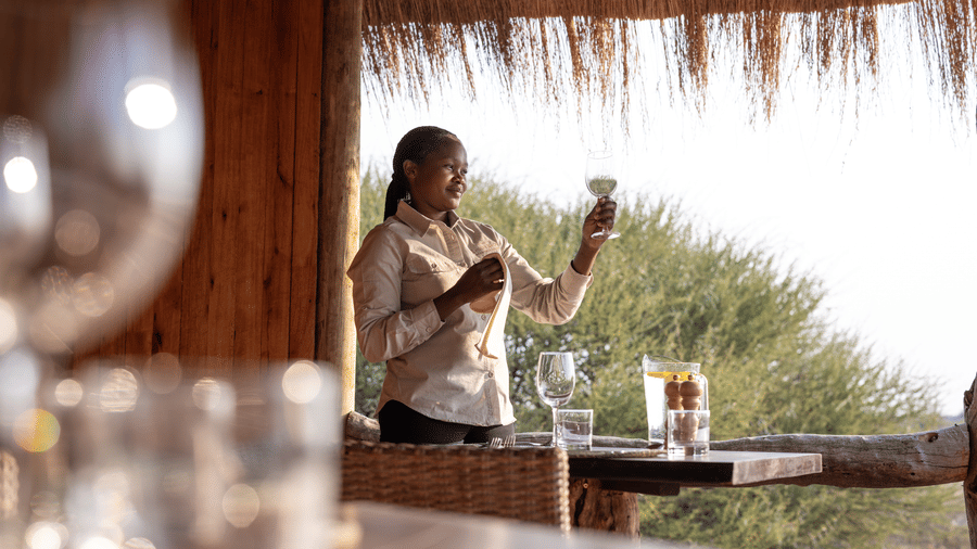Bartender serving drinks at the outdoor bar at Evolve Back Kalahari