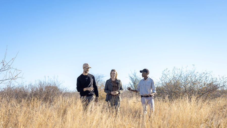Guests on a guided bush walk across open Kalahari plains near Evolve Back Kalahari