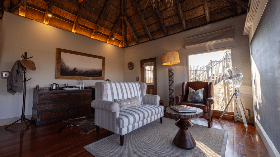 Warm suite living room with wooden floors and bush views at Evolve Back Kalahari