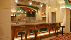  A well-lit bar area with a marble counter, bar stools, and a display of spirits - Balaji Sarovar Premiere, Solapur