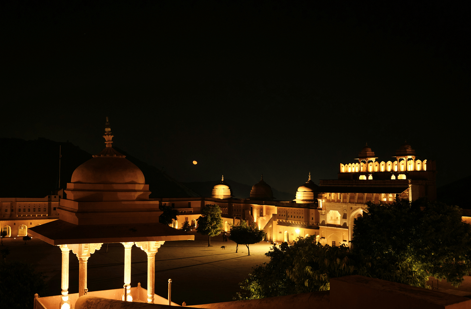 image of the amer fort in the night with bright yellow lights lit across the palace