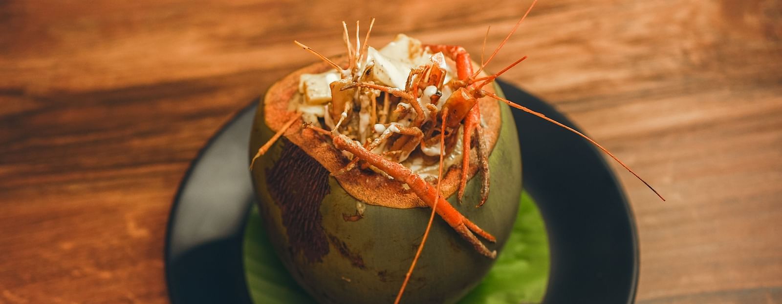 image of whole prawns made in bengali style served in a coconut shell - Dip Holidays, Birbhum
