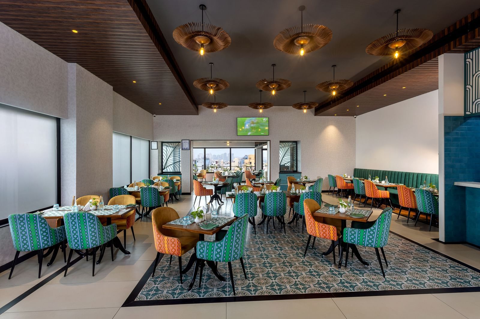 Spacious restaurant at Shalimar in Zibe Luxe Hyderabad by GRT Hotels offering a bright, city-facing setting with stylish ceiling lights.