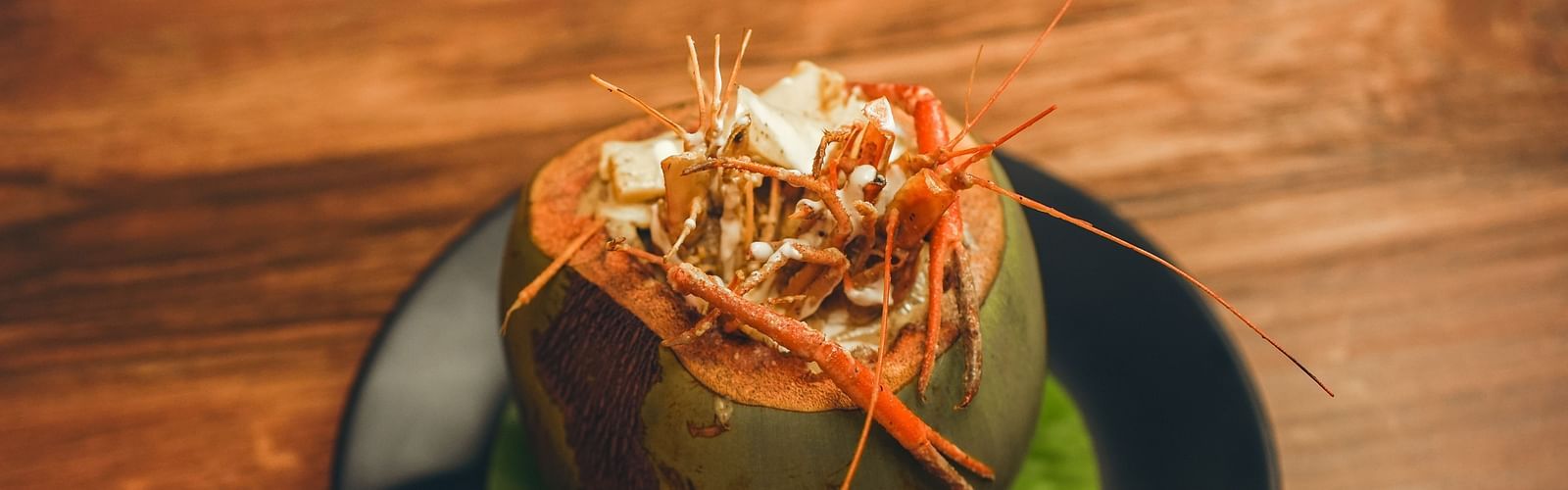 image of whole prawns made in bengali style served in a coconut shell - Dip Holidays, Birbhum