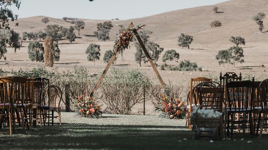 A desert with few small trees and a wedding setup.