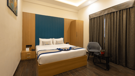 Interior view of a guest room showing the bed and window with closed curtains at Pravasa Stay Luv Kush, Indore.