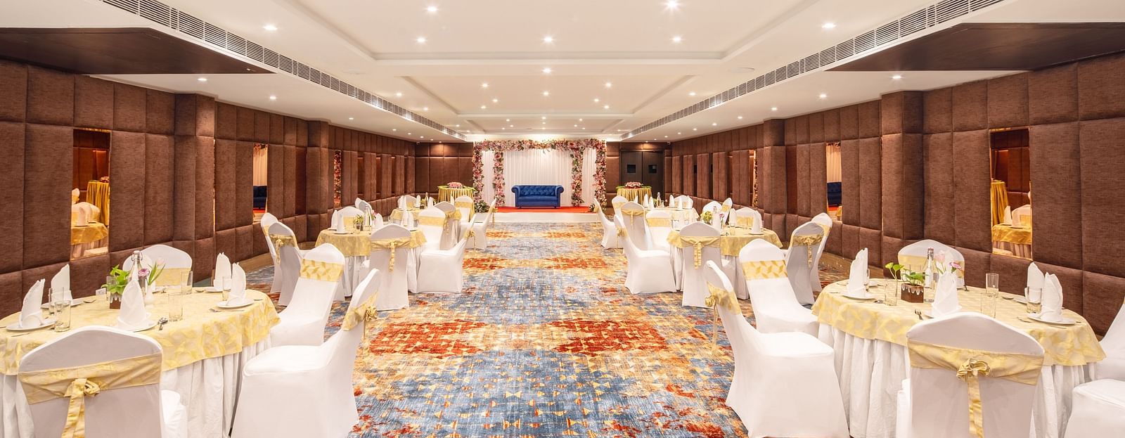 An image of a banquet hall with several chairs and table sets spread out - Brij Eternity, Vrindavan