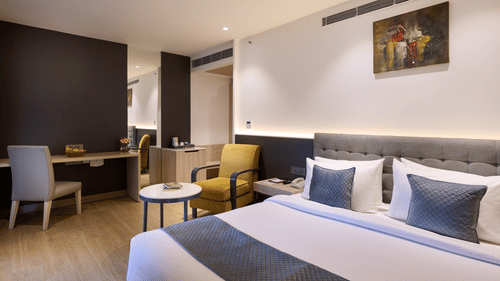 An image with a bed in the front and seating arrangement in the back