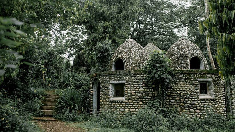 Old stone Buddhist meditation house in green garden.