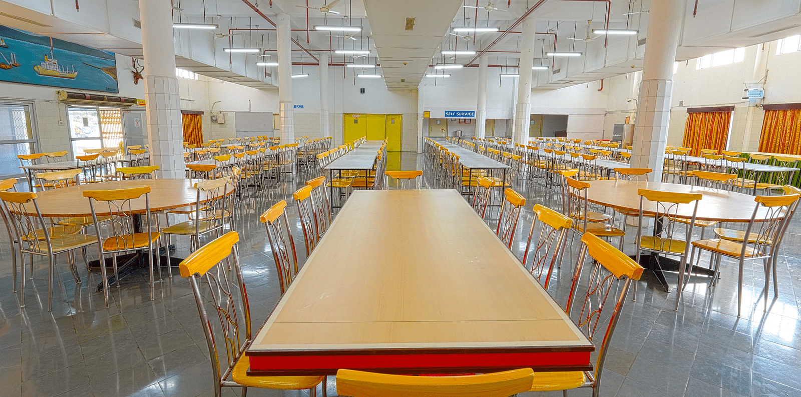 A dining hall with a long table paired with six chairs at Sahara - Group Dining in Hyderabad.