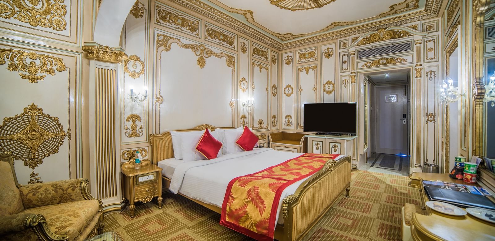 A grand hotel room with ornate decor and plush furnishings, exuding elegance and sophistication at  Sitara Luxury Hotel in Hyderabad near Ramoji Film City.