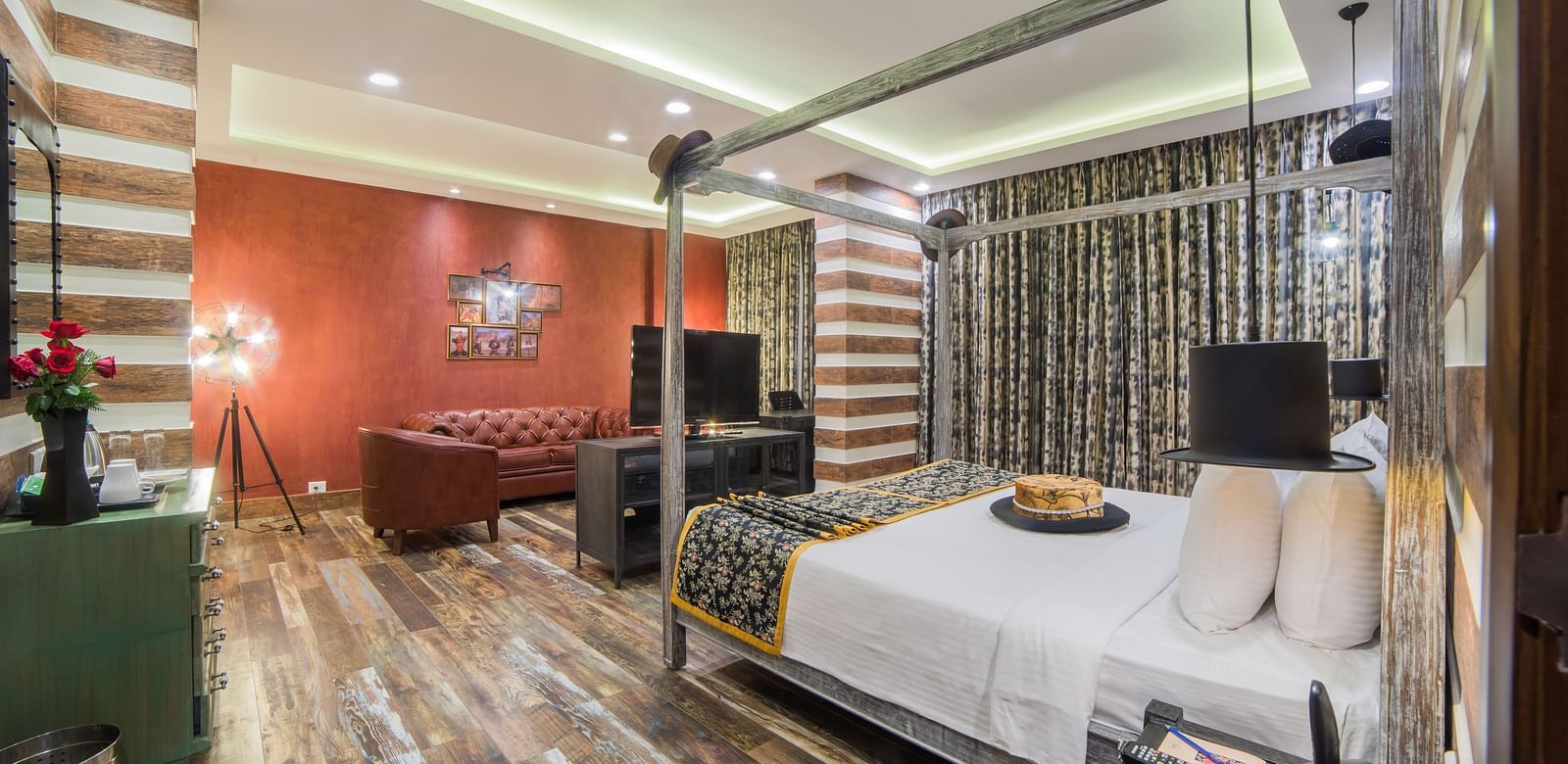 A modern hotel room with striped wall design, contrasting red accent wall, and contemporary furnishings A grand hotel suite with an opulent red and white decor, large bed, and seating area, reflecting a traditional style at Sitara Luxury Hotel in Hyderabad