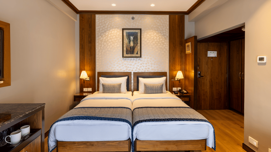 Executive Room with twin beds and framed artwork above the headboards at Kenilworth Hotel, Kolkata.