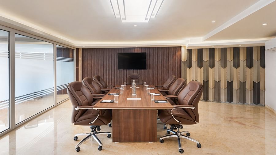 Boardroom with long wooden table, leather chairs and mounted screen at Clarks Inn Suites, Hyderabad