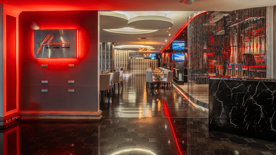 Interiors of the best restaurant in Sukhumvit, featuring dramatic red ambient lighting, glossy black finishes, and a contemporary dining entrance | Night Hotel, Bangkok